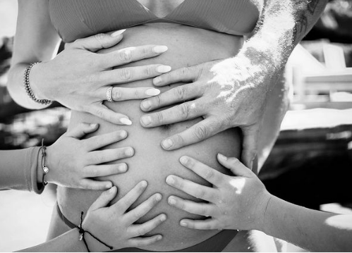main sur un ventre enceinte