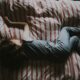kid sleeping on red and gray bed
