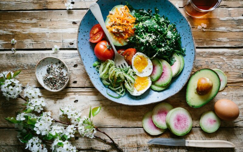 poached egg with vegetables and tomatoes on blue plate