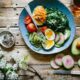 poached egg with vegetables and tomatoes on blue plate